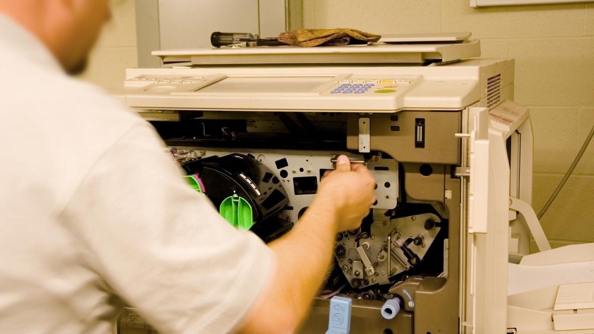 Certified technician repairing a commercial copier at a Phoenix business office